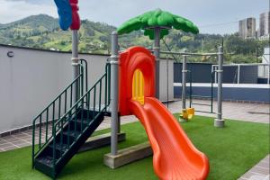 a playground with a slide and an umbrella at Apartamento completo en Sabaneta in Sabaneta
