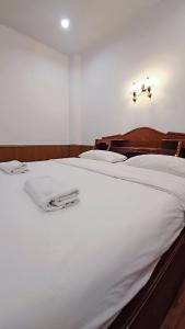 a large white bed with white sheets on it at Home 24 Pattaya in Pattaya