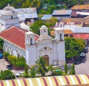 a large white church with a red roof at Hotel Boutique las Colinas in San José de Colinas +6 photos