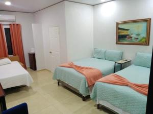 a room with two beds and a painting on the wall at Hotel Boutique las Colinas in San José de Colinas