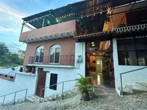 a house with a balcony on the side of it at Hotel Boutique las Colinas in San José de Colinas