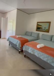 a hotel room with two beds and a couch at Hotel Boutique las Colinas in San José de Colinas