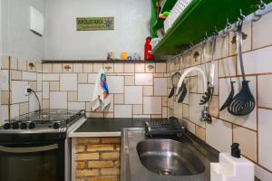 a kitchen with a sink and a stove at Villa do Portinho - Casas em frente à Praia in Ilhabela +260 photos