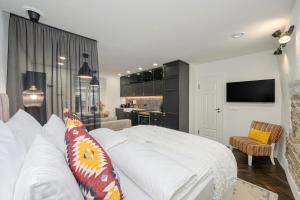 Un dormitorio con una gran cama blanca y una cocina. en Tallinn Old Hanza Apartments, en Tallin
