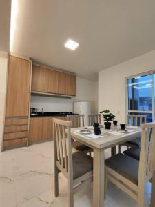 eine Küche mit einem Tisch und zwei Stühlen und einem Tisch und einer Küche in der Unterkunft Residêncial Campinas a 400 Metros da praia de Palmas in Governador Celso Ramos