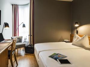 a hotel room with a bed and a desk at Mercure Hotel Berlin Zentrum Superior in Berlin +49 photos