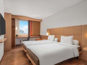 a hotel room with two beds and a desk at Ibis Gading Serpong in Serpong +21 photos