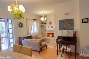 a living room with a couch and a piano at Verdalia Private Holiday House in Stavrákia