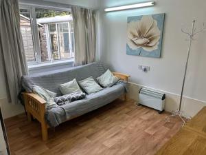 a living room with a couch and a window at Emsworth Studio - With Hot tub only Oct to April in Emsworth