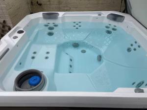 a white bath tub with a blue light in it at Emsworth Studio - With Hot tub only Oct to April in Emsworth