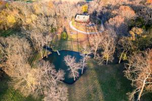 an aerial view of a house and a lake at 15 Mins to U of A - Pool & Hot Tub in Fayetteville +47 photos