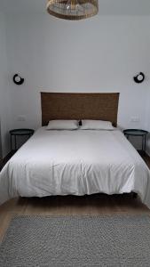 a bedroom with a white bed with two tables at La Caldera in San Bartolomé