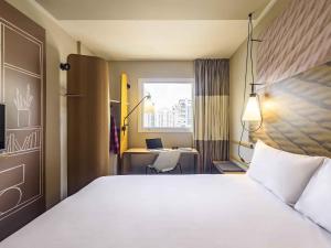 a bedroom with a bed and a desk with a laptop at ibis Sao Paulo Ibirapuera in Sao Paulo