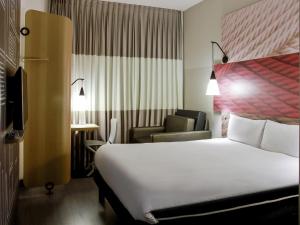 ein Hotelzimmer mit einem Bett und einem Stuhl in der Unterkunft ibis Osasco in Osasco + 51 Fotos