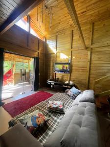 un salon avec un canapé et une télévision à écran plat dans l'établissement Casa das Pedras - Um recanto de paz em Santa Tereza, à Santa Teresa