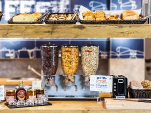 a shelf with three glasses filled with food and bread at ibis budget Saint Dié des Vosges in Saint Die