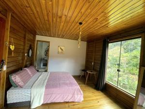 une chambre avec un lit et un plafond en bois dans l'établissement Casa das Pedras - Um recanto de paz em Santa Tereza, à Santa Teresa