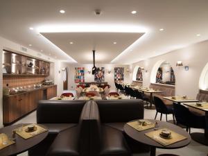 a restaurant with tables and chairs and a kitchen at Mercure Fribourg Centre Remparts in Fribourg