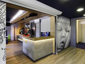 Un bar con una imagen de la cabeza de un presidente en la pared. en IBIS Budget Aix en Provence Est Le Canet, en Meyreuil