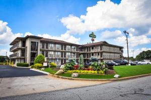 a hotel building with a garden in front of it at Masters Inn Tucker in Tucker