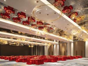 杭州市にあるSofitel Hangzhou Yingguan-Olympic Center Hotelの赤いテーブルとシャンデリアのある大きな宴会場 +90枚の写真