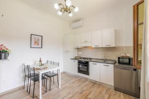 a kitchen with white cabinets and a table and chairs at Casa Emma - Private house with pool in Castiglione del Lago