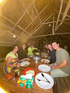 a group of people sitting around a wooden table at Fam Homestay in Fam