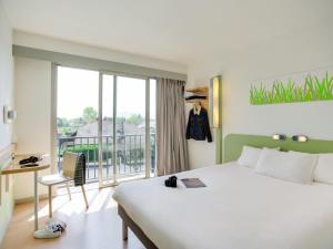 レスカーにあるibis budget Pau Lescarの大きなベッドとバルコニーがあるホテルの部屋 +61枚の写真
