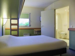a bedroom with a bed and a bathroom with a toilet at ibis budget Niort - La Crèche in La Creche +24 photos