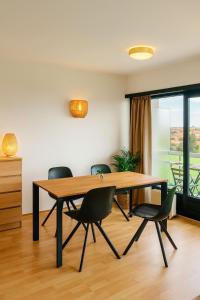 a dining room with a wooden table and chairs at Parking gratuit, piscine intérieur vue panoramique in Heist
