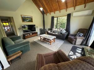 a living room filled with furniture and a flat screen tv at 18c Scarborough Tce in Hanmer Springs