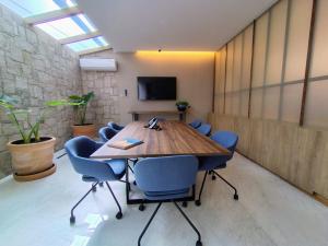 a conference room with a wooden table and blue chairs at Hotel Soretti in Durango