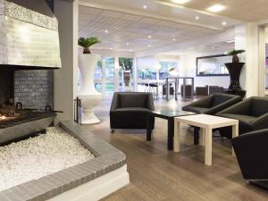 a living room with a couch and a fireplace at Novotel Fontainebleau Ury in Ury