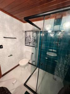 a bathroom with a toilet and a glass shower at Casa Jasmim em Domingos Martins a 5km do Centro in Domingos Martins +20 photos
