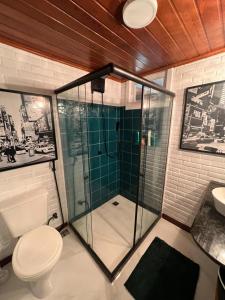 a bathroom with a shower with a toilet and a sink at Casa Jasmim em Domingos Martins a 5km do Centro in Domingos Martins
