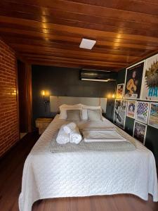 a bedroom with a large bed with towels on it at Casa Jasmim em Domingos Martins a 5km do Centro in Domingos Martins