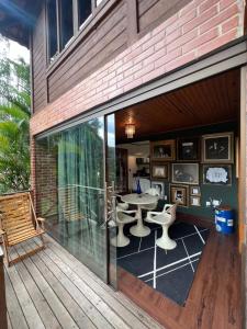 a patio with a table and chairs on a deck at Casa Jasmim em Domingos Martins a 5km do Centro in Domingos Martins