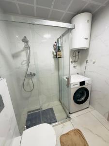 a bathroom with a shower with a washing machine at Dream Holiday Apartments in Skopje