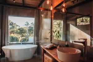 a bathroom with a tub and a large window at Chalé Climatizado com banheira em frente ao Parque do Passaúna em Curitiba by Tiny House Passaúna in Curitiba +33 photos