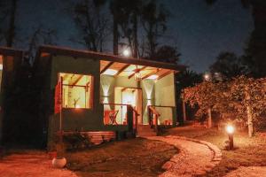 a small house at night with lights on at Chalé Climatizado com banheira em frente ao Parque do Passaúna em Curitiba by Tiny House Passaúna in Curitiba