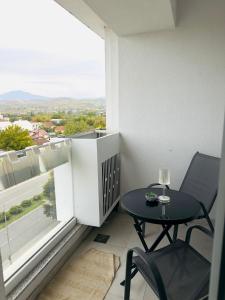 a small table and chair on a balcony with a large window at Dream Holiday Apartments in Skopje