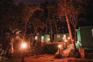 a house with lights in the yard at night at Tiny House Passaúna - Climatizado, deck e parque in Curitiba