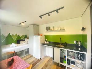 a small kitchen with a sink and a refrigerator at Tiny House Passaúna - Climatizado, deck e parque in Curitiba