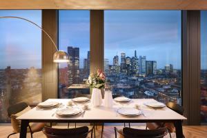 a table in a room with a view of a city at NH Collection Frankfurt Spin Tower in Frankfurt/Main