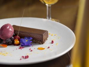 un postre de chocolate en un plato con una copa de vino en Fable Terrace Downs Resort by MGallery, en Windwhistle