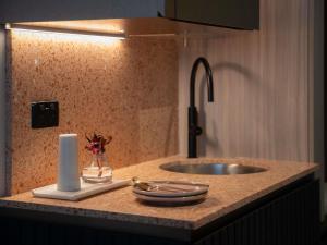 a bathroom counter with a sink and a roll of paper towels at The Sebel Sydney Martin Place in Sydney