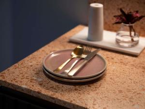 a plate with a fork and knife on a table at The Sebel Sydney Martin Place in Sydney +77 photos