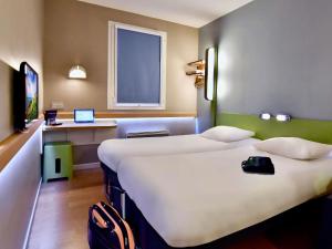 ein Hotelzimmer mit zwei Betten und einem Fenster in der Unterkunft ibis budget Brest Centre Port in Brest