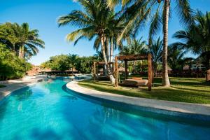 a swimming pool with palm trees and a gazebo at Iberostar Waves Para&iacute;so Beach in Puerto Morelos