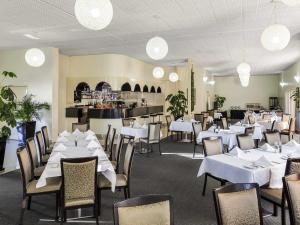 a dining room with white tables and chairs at BreakFree Queanbeyan in Queanbeyan